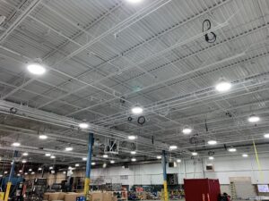 Industrial plant interior with a white metal-deck ceiling, blue columns, and yellow safety bases.