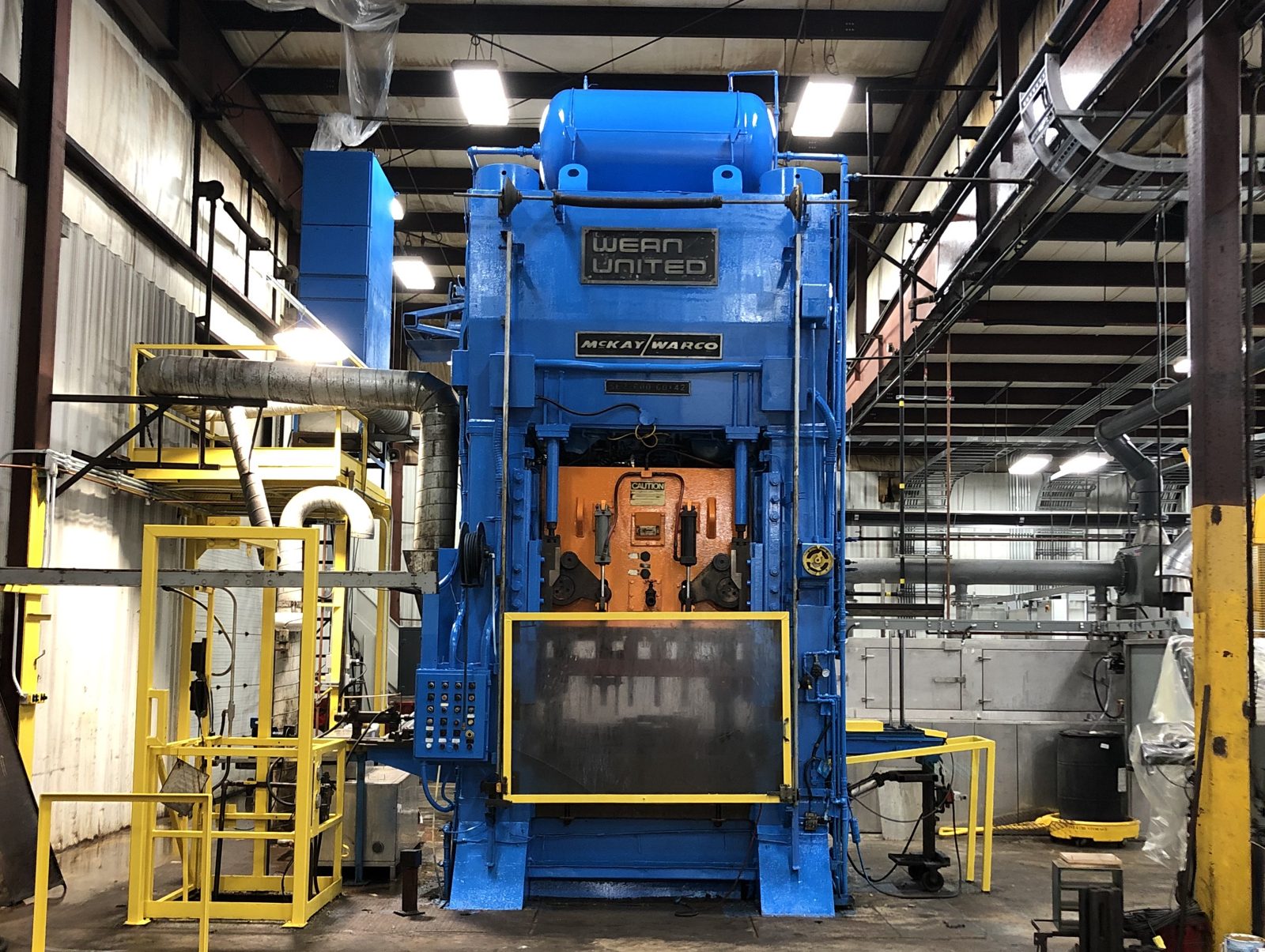 Industrial press machine freshly painted blue with yellow safety guarding